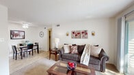 Located in O'Fallon, Missouri, this single-floor 2-bedroom, 1-bathroom residence offers a practical and comfortable layout designed to maximize everyday living. The living room serves as the heart of the home, featuring soft wall-to-wall carpeting, a textured ceiling, and a sliding glass door that opens onto a private balcony with outdoor seating and pleasant tree-line views. The space flows naturally into a dining area, creating an open and connected feel throughout. The kitchen is efficiently designed with white cabinetry, a double stainless steel sink, tile flooring, and ample counter and storage space — ideal for everyday cooking. The primary bedroom is generously sized, offering carpeted floors, a large window with natural light and outdoor views, and a textured ceiling. The second bedroom also features carpeted flooring and a sliding-door closet with built-in shelving. A hallway connects the rooms with additional closet storage along the way. The full bathroom is clean and well-lit, featuring a white vanity with cabinet storage, tile flooring, and a shower/tub combination. Throughout the residence, neutral tones and consistent finishes create a cohesive and inviting ambiance suitable for a variety of lifestyles.