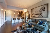 Located in the heart of Atlanta's prestigious Buckhead neighborhood (30326), this single-floor residence offers a thoughtfully designed layout with modern finishes throughout. The kitchen is a standout feature, showcasing rich dark espresso cabinetry, light quartz countertops, a classic subway tile backsplash, and a full suite of stainless steel appliances including a side-by-side refrigerator, electric range, and over-the-range microwave. Warm hardwood-style flooring runs seamlessly through the kitchen and into the living areas, adding depth and continuity. The living room is an inviting, well-proportioned space highlighted by floor-to-ceiling windows that bathe the room in natural light and frame dynamic views of the Atlanta cityscape. The bedroom continues the urban-view experience with expansive windows overlooking the city skyline, creating a bright and airy retreat. The bathroom is finished with large-format white tile flooring, a dark-toned vanity with an integrated sink, a framed mirror, and a full soaking tub and shower combination with neutral tile surround. Throughout the residence, a cohesive palette of warm neutrals, dark wood tones, and modern fixtures creates a polished and contemporary ambiance well-suited to urban living.