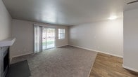 Located at 25037 45th Ave S in Kent, WA, unit N102 is a single-floor residence featuring a thoughtfully arranged layout visible through its open floor plan. The living area combines plush carpeting with wood-look hard flooring, creating a warm, transitional aesthetic. A sliding glass door floods the space with natural light and provides direct views of outdoor greenery, while an adjacent window further enhances brightness. A ceiling fan with a built-in light fixture adds both function and comfort to the living space.

The kitchen is well-appointed with white cabinetry, dark countertops, and a peninsula that offers additional prep space and serves as a natural divider between the kitchen and living areas. Stainless steel and black appliances, including a refrigerator, range, and dishwasher, complement the clean, modern aesthetic. Recessed lighting and a window above the sink contribute to a bright, practical workspace.

A dedicated laundry area with a washer and dryer is conveniently accessible from the main living space. The bathroom features a vanity with dark countertops, white cabinetry, a large mirror, and wood-look flooring. The carpeted bedroom includes a baseboard heater and a window with outdoor views, offering a quiet and comfortable retreat.