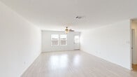Located in a well-maintained neighborhood in New Braunfels, TX, this single-story, 3-bedroom, 2-bathroom home offers a clean, modern interior with a practical and open layout. The living room is bright and inviting, featuring light wood-style flooring, crisp white walls, a ceiling fan with light fixture, and multiple windows that allow natural light to fill the space. The open-concept design connects the living area seamlessly to the dining space and kitchen. The kitchen is well-appointed with granite-style countertops, white shaker cabinetry reaching toward the ceiling, stainless steel appliances including a gas range, built-in microwave, and a French door refrigerator with ice and water dispenser, plus a single-basin sink set into the peninsula. A hallway lined with recessed lighting connects the bedrooms, each featuring light wood flooring and ceiling fans. The generously sized primary bedroom includes its own closet. The bathrooms are clean and functional, featuring tub/shower combinations with built-in corner shelving. A dedicated laundry room offers washer and dryer hookups. The attached garage adds convenience, and the home is situated on a quiet residential street within a community-oriented neighborhood.