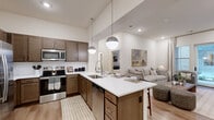 This thoughtfully designed 2-bedroom, 2-bathroom single-floor residence in Center Point, Alabama offers a comfortable and modern living experience. The open-concept kitchen and living area serves as the heart of the home, featuring rich dark-toned cabinetry, stainless steel appliances, a subway tile backsplash, and a central island with a white quartz countertop and pendant globe lighting overhead. Light wood-style flooring flows throughout, complementing the bright, neutral palette of the interiors.

The living room is bathed in natural light from large windows and a glass door that opens to the patio, creating a seamless indoor-outdoor connection. Both bedrooms are well-sized and tranquil, with generous natural light and ample closet space. The primary bedroom connects to an en-suite bathroom featuring a long single-vanity with white countertops, a soaking tub, and a walk-in closet. The second bathroom is equally well-finished with similar design elements.

Additional highlights include a dedicated laundry area, a utility room, two pantry spaces, and recessed lighting throughout. The residence strikes a balance between functional layout and refined aesthetic, making it an inviting and practical living space.