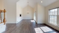 Located at 15 Kings Way in Waltham, MA, this impressive 3-floor home delivers a thoughtfully designed layout with standout architectural details throughout. The main living area commands attention with soaring vaulted ceilings, an elegant chandelier, a wood-burning fireplace, and rich hardwood flooring that flows seamlessly across the open floor plan. Natural light pours in through generous windows, enhancing the sense of volume and airiness. A staircase with a classic wood banister connects the floors with ease.

The kitchen is well-appointed with white raised-panel cabinetry, dark granite countertops, a glass mosaic tile backsplash, and stainless steel appliances, including a range and over-the-range microwave. Vaulted ceilings extend into this space as well, adding to its openness.

Upstairs, the upper level features plush carpeting, high ceilings, and access to a bathroom with a tub-shower combination and white tile flooring. Additional bathroom facilities on the main level include tile flooring and a clean, functional layout.

The attached two-car garage offers ample space with an epoxy-coated floor and dual automatic garage door openers. The basement level provides a utility and storage area with a walkout door opening to the green outdoor surroundings, completing this well-rounded home.
