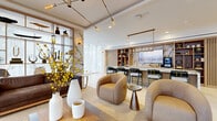 Located at 334 Second Ave S in downtown Saint Petersburg, Florida, this upscale amenity lounge delivers a refined, contemporary environment designed for comfort and social gathering. The single-floor space is defined by its open-plan layout, with large floor-to-ceiling windows draped in sheer white curtains that invite abundant natural light and views of the surrounding streetscape.

The lounge area features a curated arrangement of plush sofas and rounded upholstered accent chairs in warm earth tones, set atop woven area rugs over large-format light stone tile flooring. A sculptural open shelving unit clad in marble serves as a design focal point, displaying carefully selected decorative objects and flanked by brass-accented lighting fixtures.

At the heart of the space sits a dramatic full-length bar and communal table crafted from richly veined white and gold marble, illuminated by a sleek pendant chandelier. Built-in warm wood shelving lines the adjacent wall, housing décor and framing a large-screen display. Bar-height seating with gold-accented legs completes the social hub.

A gracefully curved stairwell clad in a textured gold mosaic wall treatment connects this level to additional areas of the building, adding an artistic architectural element. Recessed lighting and designer pendant fixtures throughout enhance the space's warm, polished ambiance.