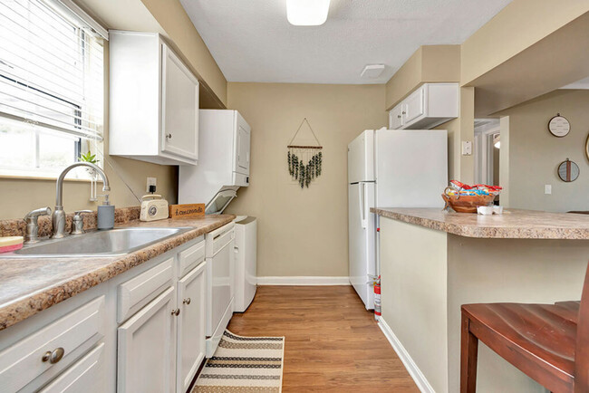 Spacious Kitchen with Ample Counter Space and Stacked Laundry Machines at The Commons Student Apartments in Oxford, OH - The Commons