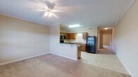 Located at 1805 8th Ave in Tuscaloosa, Alabama, this single-floor residence offers a well-organized layout with a seamless blend of functionality and comfort. The open-concept living and dining area is finished with plush carpeting and crown molding, and features a ceiling fan with light fixture. The space flows naturally into the kitchen, which is separated by a breakfast bar peninsula. The kitchen is outfitted with rich, warm-toned wooden cabinetry, granite-style laminate countertops, black appliances including a range, over-the-range microwave, refrigerator, and dishwasher, as well as a stainless steel sink. Tile flooring runs throughout the kitchen and entry areas. The bedrooms are generously sized, carpeted, and finished with neutral wall tones. One bedroom opens directly to a private outdoor patio through French doors, allowing natural light to fill the room. The bathroom features a rich wood vanity with a white countertop, a large wall mirror with overhead lighting, and clean tile flooring. Crown molding and ceiling fans are consistent design elements that lend a polished feel throughout the home. The overall ambiance is warm, practical, and move-in ready, suited for comfortable everyday living in a convenient Tuscaloosa location.