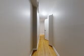This one-bedroom, one-bathroom unit in New Westminster, BC offers a well-organized layout across a single floor, making efficient use of its compact footprint. Warm-toned hardwood flooring flows consistently through the hallway, living room, and bedroom, lending the space a cohesive and inviting character.

A central hallway connects the key areas of the unit, with clean neutral walls and flush ceiling lighting guiding the way. The living room is a comfortable, open space bathed in natural light from a large picture window that frames pleasant greenery outside, complemented by baseboard heating along the perimeter.

The kitchen is efficiently designed, featuring dark espresso cabinetry with brushed hardware, a tile backsplash, white appliances including a full-size refrigerator and electric range, and light-toned ceramic tile flooring. Track lighting above provides practical illumination throughout.

The bedroom is a calm and well-proportioned retreat with its own window overlooking lush outdoor greenery, hardwood flooring, baseboard heating, and a mirrored sliding-door closet that adds both storage and a sense of depth to the room.

The bathroom is finished with warm beige floor and wall tiles, a soaker tub with a tiled surround, a toilet, and a dark wood vanity, creating a clean and functional space. Overall, the unit presents a practical and comfortable living environment with consistent finishes throughout.
