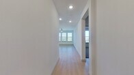 This well-appointed 2-bedroom, 2-bathroom residence spans a single floor and offers a thoughtfully designed open-concept layout. Light wood flooring flows throughout the main living areas, creating a bright and cohesive aesthetic. The hallway leads directly into the combined kitchen and living room, where large windows flood the space with natural light. The kitchen is a standout feature, equipped with gray shaker-style cabinetry, granite countertops, a white hexagonal tile backsplash, stainless steel appliances, and a generous center island with pendant lighting overhead — ideal for both cooking and casual dining. The primary bedroom is a comfortable retreat featuring multiple windows, a ceiling fan, and plush carpet underfoot, complemented by a dedicated walk-in closet with built-in shelving. The en-suite primary bathroom offers a granite-topped double vanity with gray cabinetry, a glass-enclosed shower, and wood-look tile flooring. The second bedroom is also carpeted and benefits from ample natural light through multiple windows and its own ceiling fan. The second bathroom includes a full soaking tub with tiled surround. Two closets, a hallway, and a dedicated kitchen area round out the functional floor plan of this well-designed residence.