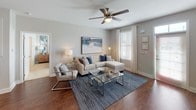 This single-floor residence offers a thoughtfully designed layout that balances comfort and modern style throughout. The living room serves as the heart of the home, featuring rich hardwood-style flooring, neutral walls, and a ceiling fan that enhances the bright, airy atmosphere. Large windows dressed with white curtains and blinds invite generous natural light, while the open layout flows seamlessly to adjacent spaces.

The kitchen is outfitted with dark espresso cabinetry, granite countertops, and a full suite of stainless steel appliances, including a range, over-the-range microwave, and refrigerator. Hardwood-style flooring continues here, complementing the sleek, contemporary cabinetry hardware and under-cabinet lighting.

The primary bedroom is a spacious retreat with plush carpeting, a ceiling fan, and a walk-in closet. Its en-suite bathroom features a double-sink vanity with granite countertops, dark cabinetry, hardwood-style flooring, and a shower-tub combination. A second bedroom, equally well-appointed with carpet and a ceiling fan, is served by a second full bathroom that mirrors the refined finishes found throughout the home. Each room reflects a cohesive design aesthetic, combining warm wood tones with neutral palettes for a polished, inviting atmosphere.