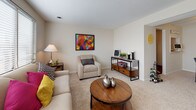 The Birch is a thoughtfully designed 2-bedroom, 1-bathroom residence that makes excellent use of its single-story layout. The living room serves as the heart of the home, featuring plush wall-to-wall carpeting, neutral warm-toned walls, and large windows fitted with horizontal blinds that allow generous natural light to fill the space. The open feel is enhanced by a seamless connection to the dining area, which offers dedicated space for a full dining table and is adjacent to the kitchen pass-through.

The kitchen is well-appointed with white cabinetry, granite-style countertops, a textured stone tile backsplash, and hardwood-style flooring. It includes a full suite of appliances — range, dishwasher, and refrigerator — providing practical functionality.

Both bedrooms are carpeted and bright, each featuring windows with natural light and ample room for full-sized furniture. One bedroom includes built-in shelving, adding useful storage. The shared full bathroom features a tub/shower combination with tiled surround.

Throughout the home, the neutral color palette and soft carpeting create a cohesive, comfortable ambiance. The efficient single-floor plan ensures easy accessibility and a natural flow between all living spaces, making The Birch a well-rounded and inviting residence.