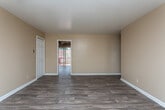 Located at 3775 Houston Ave in Macon, Georgia, this single-floor unit offers a practical and functional layout with consistent finishes throughout. The living area is finished with warm wood-look vinyl plank flooring and neutral beige walls, creating a clean and open feel. Natural light filters in through windows, adding brightness to the space.

The kitchen is well-equipped with warm-toned wooden cabinetry extending to the upper walls for ample storage, light-colored countertops, a double-basin sink, and a white electric range. A full-size refrigerator is also included. The kitchen connects directly to the main living area, supporting an open flow between spaces.

The bedrooms feature plush carpeting and neutral wall tones, providing a comfortable and quiet retreat. Each bedroom benefits from natural light via windows with exterior views. A walk-in closet with built-in shelving and hanging rods offers generous storage capacity.

The bathroom includes a full tub and shower combination with white tiled walls and a window for natural ventilation. Wood-look flooring continues into this space for a cohesive aesthetic.

Throughout the unit, white baseboards provide clean contrast against the flooring, and the overall layout—as seen in the floorplan view—is compact yet efficiently organized for comfortable single-floor living.