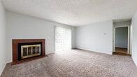Located at 3924 SW Twilight Dr in Topeka, Kansas, this single-floor, one-bedroom, one-bathroom residence offers a practical and comfortable layout. The living room serves as the heart of the home, highlighted by a brick-surround fireplace with a gold-trimmed glass door, plush wall-to-wall carpeting, a textured ceiling, and a large sliding glass door fitted with vertical blinds that fills the space with natural light and provides outdoor views. The galley-style kitchen is efficiently arranged with gray cabinetry, light countertops, wood-look vinyl flooring, and white appliances including a range, refrigerator, and dishwasher, along with an undermount sink. The generously sized bedroom features soft carpeting, a ceiling fan, a window with natural light, and direct access to a dedicated closet. The bathroom is neatly appointed with a vanity featuring gray cabinetry and a stone-look countertop, a mirrored medicine cabinet, a tiled tub-shower combination, and wood-look vinyl flooring. Neutral tones and clean finishes throughout create a bright, cohesive ambiance well-suited for comfortable everyday living.