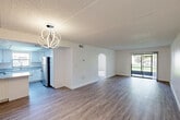 Located at 578 Reed Canal Rd in South Daytona, Florida, this single-floor, one-bedroom, one-bathroom unit offers a practical and well-organized layout. The open-concept kitchen and living room serve as the heart of the home, with the living area showcasing wood-look luxury vinyl flooring and a sliding glass door that fills the space with natural light and provides direct access to a private patio with outdoor views. The kitchen is well-appointed with crisp white cabinetry, granite-style countertops, stainless steel appliances including an electric range and refrigerator, and a window above the sink that brings in additional natural light. The spacious bedroom features plush carpeting, two large windows dressed with vertical blinds offering views of the surrounding greenery, and access to a dedicated closet. The bathroom includes a full tub-shower combo with classic white subway tile surround and brushed gold fixtures, complemented by granite-style counters consistent with the kitchen's aesthetic. A hallway connects the living spaces to the private quarters, contributing to an efficient and cohesive floor plan. Throughout, the unit maintains a clean, bright, and neutral palette, creating a welcoming and move-in-ready atmosphere.