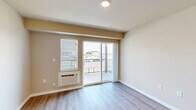 Located in Airway Heights, WA, this 2-bedroom, 1-bathroom unit offers a practical and comfortable single-floor layout. The living area features light-toned luxury vinyl plank flooring and warm neutral walls, creating a bright, welcoming atmosphere. A sliding glass door opens to a private balcony with outdoor views, allowing natural light to fill the space. The kitchen is equipped with rich dark cabinetry, light countertops, and black appliances including a refrigerator, electric range, and microwave, accented by a pendant light overhead. Both bedrooms are carpeted for comfort — the primary bedroom is generously sized and includes a walk-in closet with built-in shelving, while the secondary bedroom features a window with natural light. The bathroom includes a full shower-tub combo and is conveniently located adjacent to the dedicated in-unit laundry area, which houses a full-size washer and dryer. A hallway connects the rooms cohesively throughout the unit. With clean finishes, efficient use of space, and practical amenities, this unit offers a well-rounded living environment in a residential Airway Heights community.