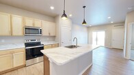 Located at 7911 Hinckley Rd in Baxter, Minnesota, this thoughtfully designed one-bedroom, one-bathroom unit offers a comfortable and modern living experience within a compact, efficient footprint. The open-concept layout connects the kitchen and living room seamlessly, creating a bright and functional common area.

The kitchen is a standout feature, showcasing a large central island with striking marble-look quartz countertops, an undermount sink, and brushed gold fixtures. Light natural wood cabinetry lines the walls, complemented by matching marble-look countertops along the perimeter. Stainless steel appliances — including a refrigerator, range, and over-the-range microwave — complete the well-equipped space. Stylish industrial pendant lights hang above the island, adding a contemporary touch.

The living room features light wood-style flooring and a sliding glass door that invites natural light and provides outdoor access. The bedroom offers plush carpeting, neutral warm-toned walls, and a window that brings in additional natural light, creating a restful retreat. A dedicated closet provides convenient storage.

The bathroom is clean and functional, featuring light wood-style flooring, a rich wood-toned vanity with ample storage, and a full tub-shower combination. Throughout the unit, a neutral color palette and recessed lighting contribute to a bright, welcoming ambiance.