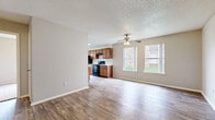 Located at 4500 Campus Dr in Fort Worth, TX, this single-floor unit offers three bedrooms, three bathrooms, and a practical, well-organized layout. The living room features wood-style laminate flooring, a ceiling fan, a textured ceiling, and a window that brings in natural light, creating a welcoming common area. Adjacent to the living space, the galley-style kitchen is equipped with warm honey-toned wood cabinetry, white subway tile backsplash, light countertops, black appliances including a range and refrigerator, a double sink, and a window overlooking the exterior — providing ample storage and counter space for everyday cooking. The three bedrooms are finished with plush carpeting and feature windows with outdoor views of the surrounding grounds. The primary bedroom includes a closet for dedicated storage. Each of the three bathrooms is appointed with wood-style flooring, a vanity with warm wood cabinetry and a wall mirror, and a shower-tub combination with clean white tile surround. Neutral tones and consistent finishes throughout the unit create a cohesive and functional living environment, well-suited for a variety of lifestyle needs.