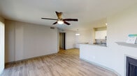 This single-story residence offers a well-designed, functional layout with consistent wood-style flooring running throughout the entire unit. The open-concept living area serves as the heart of the home, featuring a ceiling fan with light fixture, a fireplace with a simple mantel, and direct sightlines to the kitchen. Natural light enters through windows dressed with horizontal blinds, and a sliding glass door with vertical blinds provides additional brightness.

The kitchen is designed for efficiency, featuring a galley-style configuration with granite countertops, white upper cabinetry, gray lower cabinetry, a stainless steel sink, and a full suite of stainless steel appliances including a refrigerator, electric range, microwave, and dishwasher. A peninsula with matching granite countertops separates the kitchen from the living area, and a pendant light fixture adds definition to the dining space.

The bedrooms are comfortably sized, each with wood-style flooring and windows that allow natural light and outdoor views. The bathrooms maintain the same design consistency, featuring granite-topped white vanities, framed mirrors, and a tub-shower combination. A hallway connects the private areas of the unit, with additional storage accessible via a closet in the kitchen.