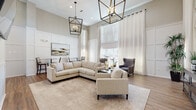 This single-floor community amenity space combines sophisticated design with practical functionality. The centerpiece is a spacious lounge area distinguished by soaring ceilings, warm wood-look flooring, and an abundance of natural light streaming through large windows dressed in sheer white curtains. Striking black metal lantern-style pendant chandeliers hang dramatically overhead, complementing the neutral palette of soft grays and warm beiges. Elegant wainscoting panels line the walls, adding a refined architectural detail throughout. Comfortable seating arrangements — including a generous sectional sofa, accent armchairs, and intimate bistro-height seating — create a welcoming environment suited for both socializing and quiet relaxation. A wall-mounted media console and curated greenery add finishing touches to the lounge.

Adjacent to the lounge, the fitness center is thoroughly equipped with multiple treadmills, an elliptical machine, a multi-station cable gym, free weights, and a wall-mounted television, all set on durable wood-look flooring with ample natural light from exterior windows. A water cooler and accessible storage complete the workout space.

Additional amenities include a shared laundry room outfitted with multiple washers and dryers, and a Luxer One smart package locker system for convenient, secure parcel retrieval.