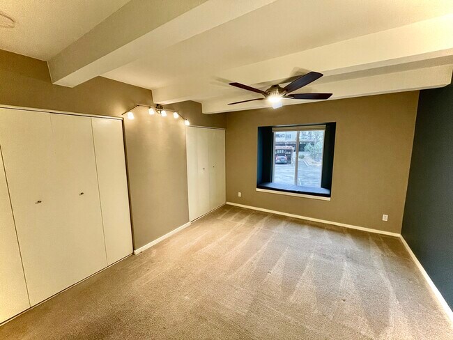 Master bedroom with full-wall closet, fan, and window nook, perfect for reading or relaxing - 2525 S Dayton Way