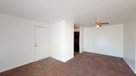 Located at 7433 3rd Street Rd in Louisville, Kentucky, this single-floor unit offers a straightforward and functional layout spread across several rooms. The living area is generously sized, featuring wall-to-wall brown carpeting, a textured ceiling, and a ceiling fan with a light fixture to provide comfort and air circulation. A front entry door opens directly into this space, which flows toward the kitchen area. Vertical blinds along one wall allow for natural light and access to the exterior.

The kitchen is equipped with dark cabinetry on both the upper and lower sections, contrasting with white laminate countertops and a white electric coil range. A stainless steel double-basin sink sits beneath the cabinetry, and wood-look flooring grounds the cooking space with a warmer tone.

The bedrooms are carpeted and finished with white walls and clean white baseboards. Each room benefits from windows fitted with horizontal blinds that let in ample natural light, lending the rooms a bright and open feel. The textured ceilings are consistent throughout the unit, contributing to a cohesive interior aesthetic. Overall, the space presents a practical and livable layout well-suited for everyday residential use.