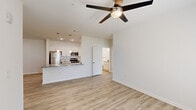 Located at 10293 Cassle Rd in Denham Springs, Louisiana, this single-story, 3-bedroom, 2-bathroom home offers a clean, modern aesthetic with a thoughtfully designed open floor plan. Light wood-look flooring runs throughout the home, complementing the bright white walls and creating a cohesive, airy feel.

The heart of the home is the open-concept kitchen and living area. The kitchen features white shaker-style cabinetry extending to the ceiling, granite countertops, stainless steel appliances including a refrigerator, range, and microwave, and a large peninsula island with a sink and pendant lighting above — ideal for both meal prep and casual dining. The adjacent living room is generously sized with a ceiling fan and recessed lighting.

The primary bedroom is a comfortable retreat, featuring natural light from large windows with blinds, a ceiling fan, and direct access to a walk-in closet with wire shelving. The primary bathroom is appointed with granite countertops, white cabinetry with brushed nickel hardware, a large vanity mirror, and a linen closet. The secondary bathroom includes a full tub-shower combination with brushed nickel fixtures.

The two additional bedrooms mirror the home's clean design with ceiling fans, natural light, and closet access, making this home as functional as it is stylish.
