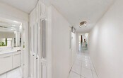 Located at 3720 Inverrary Dr in Lauderhill, Florida, this efficiently designed studio offers a well-organized single-floor layout that maximizes every square foot. The main living area seamlessly integrates sleeping, dining, and living functions into one open space, finished with gleaming white large-format tile flooring throughout. A ceiling fan with built-in lighting anchors the room, while recessed lighting along the perimeter adds a polished, modern touch. Large sliding glass doors flood the space with natural light and frame a verdant, tree-lined outdoor view, creating a refreshing sense of openness and connection to nature.

The kitchen is accessible via a pass-through window, offering a practical and space-conscious design. A bright, white-tiled hallway lined with four generously sized closets provides exceptional storage capacity, a notable feature for a studio layout. The bathroom is fully tiled in crisp white marble-look tile from floor to ceiling, equipped with a wide vanity, a large wall mirror, recessed lighting, and safety grab bars — combining both style and functionality. A dedicated utility room rounds out the floor plan. The consistent use of white tones and tile throughout the unit creates a clean, airy, and cohesive aesthetic.