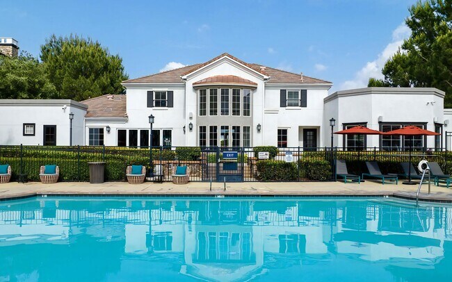 Casa club con vista a la piscina, tumbonas y sombrillas - Villas at the Gardens