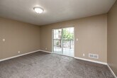 Located at 3406 Steamboat Way in Muscatine, Iowa, this two-bedroom, two-bathroom residence offers a practical and comfortable single-floor layout with a warm, neutral color palette throughout. The living room is carpeted and filled with natural light, anchored by a sliding glass door that opens to a private balcony with outdoor views. The kitchen is well-appointed with rich, dark wood cabinetry, granite-style countertops, light hardwood-style flooring, and a full suite of stainless steel appliances including a range, microwave, dishwasher, and refrigerator. Both bedrooms feature soft carpeting and generous closet space, including a double-door closet in the primary bedroom. Each room is brightened by windows that bring in natural light. The two full bathrooms are consistently finished with stone-tile flooring, wood-tone vanities with dark countertops, and full tub-shower combinations. Additional conveniences include a dedicated laundry area, utility room, and ample closet storage throughout. Textured ceilings are consistent across the home, contributing to its cohesive, understated aesthetic. The layout flows efficiently through a central hallway connecting all rooms.