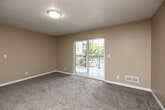 Located at 3406 Steamboat Way in Muscatine, Iowa, this two-bedroom, two-bathroom residence offers a practical and comfortable single-floor layout with a warm, neutral color palette throughout. The living room is carpeted and filled with natural light, anchored by a sliding glass door that opens to a private balcony with outdoor views. The kitchen is well-appointed with rich, dark wood cabinetry, granite-style countertops, light hardwood-style flooring, and a full suite of stainless steel appliances including a range, microwave, dishwasher, and refrigerator. Both bedrooms feature soft carpeting and generous closet space, including a double-door closet in the primary bedroom. Each room is brightened by windows that bring in natural light. The two full bathrooms are consistently finished with stone-tile flooring, wood-tone vanities with dark countertops, and full tub-shower combinations. Additional conveniences include a dedicated laundry area, utility room, and ample closet storage throughout. Textured ceilings are consistent across the home, contributing to its cohesive, understated aesthetic. The layout flows efficiently through a central hallway connecting all rooms.