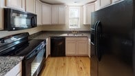 Located at 28 Maverick Dr in Pendleton, SC, this multi-story home spans three floors and offers a well-organized layout with a range of practical features throughout. The main living areas are finished with warm, light-toned hardwood floors that run through multiple rooms, lending a cohesive and inviting character to the interior.

The kitchen is thoughtfully equipped with white cabinetry extending to the ceiling, dark granite countertops, black appliances including a range, dishwasher, microwave, and refrigerator, and a double sink positioned beneath a window that brings in natural light.

Multiple bathrooms are distributed across the floors, each featuring tub-shower combinations, white vanities, and a mix of hardwood and tile flooring. Natural light filters into the bathrooms through frosted or slatted windows, maintaining both brightness and privacy.

Living spaces are bright and open, with large windows dressed in white blinds that allow ample daylight. Rooms include closet access and wall-mounted fixtures. One room features a wall-mounted television, adding a functional media space to the home.

The stairways connecting the three floors are carpeted and illuminated by wall sconces, creating a warm and navigable transition between levels. Throughout, the home maintains a clean, neutral palette of warm whites and beiges.