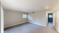 Located at 6131 North 16th Street in Phoenix, Arizona, this single-story, 2-bedroom, 1-bathroom home offers a clean, modern aesthetic throughout its efficiently designed floor plan. Neutral-toned walls, crisp white baseboards, and durable light wood-style flooring create a cohesive, contemporary look across every room.

The living room is a bright, open space benefiting from a sliding glass door and an additional window, allowing natural light to fill the room and providing access to the outdoors. The galley-style kitchen is well-appointed with white shaker cabinets, white subway tile backsplash, light quartz countertops, and a full suite of stainless steel appliances including a range, microwave, refrigerator, and dishwasher. A dedicated laundry area with side-by-side washer and dryer units, overhead cabinetry, and a ceiling fan adds everyday convenience.

The spacious primary bedroom offers generous proportions with natural light from a window, while the second bedroom provides a comfortable, versatile space. The bathroom features a full tub-shower combination, a vanity with cabinet storage, and light wood-style flooring consistent with the rest of the home. A connecting hallway ties the layout together efficiently, making the overall flow of the space practical and intuitive.