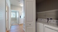 This single-floor residence offers a well-organized layout with a cohesive, contemporary design. The open living area is a standout feature, bathed in natural light from multiple windows fitted with horizontal blinds that frame outdoor views. Warm hardwood-style flooring runs throughout the main living spaces, lending a clean and inviting feel.

The kitchen is efficiently designed with white cabinetry, light countertops, and a full suite of stainless steel appliances, including a range, over-the-range microwave, refrigerator, and dishwasher. A sliding glass door provides additional natural light and outdoor access.

Bedrooms are finished with plush carpeting and neutral-toned walls, creating a calm and comfortable atmosphere. Each room includes closet storage, with wire shelving for organization. The bathroom features wood-style flooring, a soaking tub, a white vanity with light countertops, and chrome fixtures.

A dedicated in-unit laundry closet houses a full-size washer and dryer with overhead shelving. Throughout the space, raised-panel white doors and clean white trim provide a polished, uniform finish that ties the entire home together.