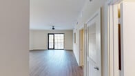 This well-appointed single-floor residence at 6600 Main St in Miami Lakes, Florida, offers a thoughtfully designed layout with modern finishes throughout. The open-concept living and dining area is bright and welcoming, featuring wood-style plank flooring, a ceiling fan, and expansive floor-to-ceiling glass doors that lead to a private balcony, flooding the space with natural light and providing views of the surrounding greenery.

The kitchen is equipped with stainless steel appliances, including a refrigerator, range, and built-in microwave, complemented by rich dark wood cabinetry, a mosaic tile backsplash, and a generous quartz-topped island with an undermount sink — ideal for both cooking and casual dining. A dedicated in-unit laundry room with a full-size washer and dryer adds everyday convenience.

The bedrooms are carpeted for comfort, each offering ceiling fans or roller shades and ample natural light. The primary bedroom includes access to a spacious walk-in closet with built-in shelving. The primary bathroom features a dual-sink vanity with dark wood cabinetry, a glass-enclosed shower, and a soaking tub with tile surround. A second well-appointed bathroom includes a tub-shower combination with tile surround and a single-sink vanity.