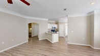 Located in Austin, TX (78754), this single-story 2-bedroom, 2-bathroom home offers a thoughtfully designed layout with a warm, neutral color palette and quality finishes throughout. The open-concept living and kitchen area serves as the heart of the home, featuring light wood-style flooring, crown molding, and a ceiling fan with light fixture. The kitchen is equipped with white shaker-style cabinetry, granite countertops, stainless steel appliances including a refrigerator, microwave, and range, and a peninsula island with a sink — all complemented by natural light from a large window. An elegant arched passageway connects the living areas, adding architectural character. The front entry welcomes with a transom-windowed door and a bright hallway that flows naturally into the main living space. Both bedrooms are carpeted and feature ceiling fans, natural light from windows, and a comfortable sense of space; the primary bedroom includes a dedicated closet area. The two bathrooms mirror the home's refined aesthetic with granite-topped vanities and wood-style flooring. A dedicated laundry room with washer and dryer hookups and overhead shelving adds everyday convenience. Crown molding and arched details lend a classic touch throughout this well-designed Austin home.