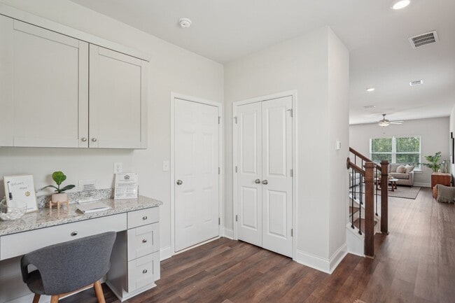The entrance to the Aberdeen home featuring rich hardwood-style flooring and crisp white walls. - Satterfield Commons