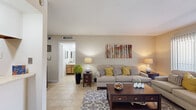 Located at 6565 Spencer Hwy in Pasadena, TX, this single-floor residence offers a well-organized layout that makes efficient use of its compact footprint. Light tile flooring runs throughout, lending a cohesive and clean aesthetic to every room.

The living room serves as the heart of the home, featuring a bright, open feel with natural light streaming in through sliding glass doors dressed with vertical blinds. The space comfortably accommodates full seating arrangements, creating an inviting area for relaxing or entertaining.

Adjacent to the living room, the combined dining area provides dedicated space for a full-sized dining table, complemented by a decorative wall mirror that adds depth to the room. The kitchen runs alongside the dining space and is equipped with wooden cabinetry, light countertops, a double-basin sink, a black electric range, and a refrigerator — providing all essential appliances in a practical galley-style configuration.

The bedroom is a well-proportioned retreat, featuring a ceiling fan, a sliding glass door with patterned drapes allowing soft natural light, and a dedicated closet. The bathroom, visible from the living area, includes a well-lit vanity with wooden cabinetry. Overall, the space presents a functional and comfortable single-bedroom layout.