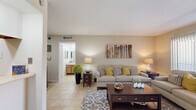 Located at 6565 Spencer Hwy in Pasadena, TX, this single-floor residence offers a well-organized layout that makes efficient use of its compact footprint. Light tile flooring runs throughout, lending a cohesive and clean aesthetic to every room.

The living room serves as the heart of the home, featuring a bright, open feel with natural light streaming in through sliding glass doors dressed with vertical blinds. The space comfortably accommodates full seating arrangements, creating an inviting area for relaxing or entertaining.

Adjacent to the living room, the combined dining area provides dedicated space for a full-sized dining table, complemented by a decorative wall mirror that adds depth to the room. The kitchen runs alongside the dining space and is equipped with wooden cabinetry, light countertops, a double-basin sink, a black electric range, and a refrigerator — providing all essential appliances in a practical galley-style configuration.

The bedroom is a well-proportioned retreat, featuring a ceiling fan, a sliding glass door with patterned drapes allowing soft natural light, and a dedicated closet. The bathroom, visible from the living area, includes a well-lit vanity with wooden cabinetry. Overall, the space presents a functional and comfortable single-bedroom layout.