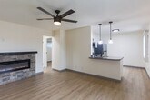 Located at 501 Plum St in the coastal city of Capitola, CA, this efficiently designed one-bedroom, one-bathroom unit offers a thoughtfully laid-out single-floor plan with modern upgrades throughout. Light wood-look flooring runs consistently across all rooms, lending a clean, cohesive aesthetic to the space.

The open living area serves as the focal point of the unit, anchored by a striking stone-surround linear electric fireplace with a dark mantle — a standout architectural feature that adds warmth and character. A ceiling fan with an integrated light fixture overhead enhances air circulation and comfort. A large window with vertical blinds allows natural light to fill the room, and a pendant light near the kitchen entry adds a stylish accent.

The kitchen is equipped with stainless steel appliances, including a refrigerator, range, and over-the-range microwave, complemented by white cabinetry and gray countertops. The bedroom offers a comfortable, quiet retreat with a sliding closet, an additional closet, and a window with outdoor views. A hallway connects the living areas to the private spaces.

The bathroom is finished with a white vanity with black hardware, a framed mirror, and a full tub-shower combination with brushed nickel fixtures. Clean white walls and wood-look flooring maintain the unit's modern, cohesive feel throughout.