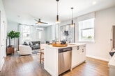 Located in the Belmont East community of Central Islip, NY, this single-floor residence offers a thoughtfully designed layout with modern finishes throughout. Light gray walls, recessed lighting, and smooth light-toned hardwood flooring create a cohesive, contemporary aesthetic from room to room.

The welcoming entryway features a tufted bench and framed coastal artwork, setting a relaxed tone. The kitchen is outfitted with white cabinetry, stainless steel appliances including a refrigerator, range, microwave, and dishwasher, paired with white countertops and a subway tile backsplash. A peninsula with bar seating and pendant lighting serves as both a dining and gathering space. A window brings in natural light and outdoor views.

The living room is bright and comfortable, with multiple windows, sheer curtains, a ceiling fan, and a wall-mounted mini-split system. The bedrooms are cozy and well-lit, each featuring windows with outdoor views and wall art.

Bathrooms are finished in white, with one featuring a glass-enclosed walk-in shower with white subway tile, and another offering a clean vanity with modern fixtures. In-unit washer access and a dedicated storage closet with built-in shelving add practical convenience throughout.