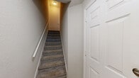 Located at 2450 Lake Debra Drive in Orlando, Florida, this three-bedroom, two-bathroom home spans three floors, offering a well-organized and functional layout. The main living level features warm wood-look flooring, crown molding, and track lighting, with an open feel accentuated by a classic staircase railing and textured ceilings. The kitchen is well-appointed with white shaker-style cabinetry, dark granite countertops, a tile backsplash, and a full suite of stainless steel appliances including a range, microwave, dishwasher, and refrigerator. A pantry with bi-fold doors provides additional storage. The bedrooms are carpeted for comfort, each featuring a ceiling fan and window with natural light and outdoor views. The generously sized primary bedroom includes a walk-in closet outfitted with wire shelving systems. A secondary bedroom offers built-in wall shelving, adding versatile storage. One of the bedrooms features hardwood-style flooring with crown molding for a refined touch. The bathrooms are finished with white cabinetry, dark countertops, tile flooring, and a shower-tub combination. Carpeted staircases with white railings connect all three levels, creating a cohesive flow throughout this well-designed home.
