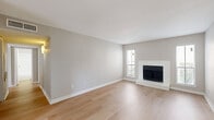 Located at 2400 Briarwest Blvd in Houston, Texas, this single-story, 3-bedroom, 2-bathroom home offers a well-organized layout designed for comfortable everyday living. The living room serves as the heart of the home, featuring light hardwood-style flooring, neutral walls, and a classic fireplace flanked by windows that invite natural light and views of the surrounding greenery. The kitchen is equipped with gray cabinetry, light countertops, a stainless steel sink, and black appliances including a refrigerator and range. A pantry provides additional storage, keeping the space practical and efficient. The primary bedroom is a generously sized retreat with hardwood-style flooring and direct access to a closet. The two additional bedrooms feature plush carpeting and ceiling fans, each with closet access, offering comfortable and functional spaces. Walk-in closet shelving provides well-organized storage throughout. Both bathrooms include tub-shower combinations with clean white tile surrounds. A hallway connects the rooms seamlessly across the single floor. The home's consistent neutral palette and mix of hard and soft flooring surfaces create a cohesive, livable ambiance throughout.