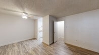 Located at 39655 Trinity Way in Fremont, California, this two-floor residence offers a practical and well-organized layout across two levels connected by an interior staircase. The main living area features wood-look laminate flooring, neutral white walls, and a textured ceiling with a ceiling fan, creating a bright and airy atmosphere. Natural light filters in through windows fitted with blinds, enhancing the open feel of the space.

The kitchen is efficiently designed with white cabinetry, a coil-burner electric range, an over-the-range microwave, and stone-look countertops, providing ample functionality for everyday cooking. Adjacent living and entry areas continue the cohesive wood-look flooring throughout.

The carpeted bedroom offers a comfortable retreat, highlighted by a sliding glass door with vertical blinds that opens to an outdoor view, along with a baseboard heating unit for year-round comfort.

The bathrooms are clean and functional; one features a tub-shower combination with chrome fixtures and a vanity with stone-look countertops, while another includes a glass-enclosed shower with wood-look flooring. Both maintain a consistent, neutral palette throughout.

The textured ceilings are consistent across the space, lending a classic residential character. Overall, this two-floor home presents a clean, move-in-ready environment well-suited for comfortable everyday living in the heart of Fremont.