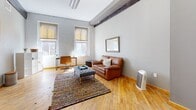 This 520 square foot apartment, located at 114 Virginia St in Richmond, VA, offers a thoughtfully designed living space within a single floor plan. The interior showcases a harmonious blend of modern amenities and rustic charm, evident in the exposed wooden beams and painted brick walls throughout.

The open-concept living area is bathed in natural light from large windows, featuring hardwood floors that add warmth to the space. A leather sofa and colorful area rug create a cozy seating area, while a flat-screen TV mounted on a wooden console provides entertainment options.

The kitchen, though compact, is well-equipped with stainless steel appliances, including a refrigerator, stove, and built-in microwave. Rich cherry wood cabinetry contrasts nicely with light granite countertops, offering both storage and preparation space. A small kitchen island doubles as a breakfast bar, maximizing functionality in the limited space.

The bedroom, measuring 130 square feet, continues the apartment's aesthetic with hardwood floors and large windows. It comfortably fits a queen-sized bed and offers built-in closet space with wooden doors. The bathroom features modern fixtures, including a vanity with cherry wood cabinetry matching the kitchen, and is adorned with neutral tones and tile flooring.

Despite its modest size, this apartment efficiently utilizes every square foot, creating a comfortable and stylish urban living space in the heart of Richmond.