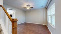 Located at 2174 Rivendell Trace in Nashville, TN, this two-story home offers a well-organized layout spread across two floors. The main level welcomes you with hardwood-style flooring throughout the living area and entry, where a large window floods the space with natural light beside a staircase featuring warm wood banisters. The kitchen is a functional highlight, showcasing dark espresso cabinetry, granite-style countertops, a central island with built-in outlets, recessed lighting, and hardwood-style floors that extend seamlessly from the adjacent dining and living areas. A half bathroom on this level adds convenience for guests. Upstairs, the layout opens to a second living area with a ceiling fan and additional hardwood-style flooring. Two bedrooms are carpeted with plush neutral tones, bathed in natural light from sizable windows. The generously sized primary bedroom includes a walk-in closet outfitted with wire shelving. Two full bathrooms complete the upper level, each featuring dark vanity cabinetry with white countertops. With three bathrooms total, two closets, and a thoughtful two-floor layout, this home delivers practical comfort in a clean, neutral palette throughout.