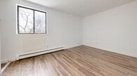 Located at 1270 Webster Street in London, Ontario, this well-appointed 2-bedroom, 1-bathroom unit offers a functional and modern living environment across a single floor. The open-concept kitchen and living room serve as the heart of the unit, featuring a peninsula-style kitchen with crisp white cabinetry, white countertops, and a full suite of stainless steel appliances including a refrigerator, stove, and microwave. Light wood-style vinyl flooring runs consistently throughout, lending warmth and cohesion to the space. Baseboard heating is present throughout the unit. The spacious living room benefits from large sliding windows that invite natural light and offer outdoor views of the surrounding neighbourhood. The generously sized primary bedroom features dual sliding closets with built-in shelving, providing ample storage. The second bedroom also includes a dedicated closet and a window with natural light and tree-lined views. The bathroom is finished with all-white tilework, a full soaker tub with shower, and clean, contemporary fixtures. The overall aesthetic is clean and neutral, with white walls and bright finishes creating a fresh, move-in-ready atmosphere throughout.