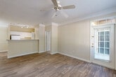 Located at 100 Ardsley Pl in Norcross, GA, this two-bedroom, two-bathroom single-floor residence offers a well-organized layout with a comfortable, functional design. The open-concept living, dining, and kitchen area serves as the heart of the home, finished with durable wood-style flooring, crown molding, and a textured ceiling. The kitchen features white cabinetry, a peninsula with a stone-style countertop, track lighting, and white appliances, opening seamlessly into the living space, which is outfitted with a ceiling fan and access to a patio through a glazed door that invites natural light. The bedrooms are carpeted for comfort, with the primary bedroom offering a generous footprint and direct access to an en-suite bathroom. Both bathrooms include white vanity cabinetry and wood-style flooring, with the bathrooms benefiting from natural light through slatted windows. The residence also includes a dedicated laundry area, a utility room, a hallway, an entrance foyer, and an impressive five closets providing ample storage throughout. Warm neutral tones carry consistently across all rooms, contributing to a cohesive and inviting ambiance throughout the home.