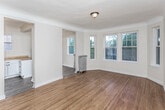 Located at 130 Glynn Ct in Detroit's vibrant 48202 zip code, this single-floor unit blends classic architectural character with thoughtful updates throughout. Hardwood flooring extends across the main living areas, lending warmth and continuity to the space. The living room is a standout feature, anchored by a curved bay window that draws in generous natural light and offers views of the surrounding neighborhood's mature tree canopy. Crown molding adds a refined architectural detail, while a classic cast-iron radiator serves as both a functional heating element and a nod to the building's historic character.

The layout flows naturally from the living area into an additional room connected by an elegant arched doorway, providing flexible use as a bedroom or secondary living space. The kitchen has been updated with white shaker-style cabinetry, butcher block countertops, a white subway tile backsplash, and stainless steel appliances, including a dishwasher. Dark hardwood flooring in the kitchen contrasts nicely with the bright cabinetry. The bathroom is clean and functional, featuring a tub-shower combination, built-in shelving, and wood-look flooring. Overall, the unit balances historic Detroit charm with practical modern updates.