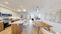 Located at 80-100 Starwood Dr in Guelph, Ontario, this thoughtfully designed 3-bedroom, 2-bathroom unit offers a bright and contemporary living experience across a well-utilized single floor. Light hardwood flooring runs throughout, complementing the clean white walls and modern finishes that define the space.

The open-concept kitchen and living area forms the heart of the unit. The kitchen features two-tone cabinetry — white upper cabinets paired with warm wood lower cabinets — white quartz countertops, stainless steel appliances, and a peninsula with a built-in sink. The adjacent living room is bathed in natural light from large sliding windows that frame sweeping views of the surrounding Guelph landscape.

The primary bedroom benefits from a tray ceiling, a generous window with scenic outdoor views, and warm hardwood floors. A second bedroom includes a built-in double closet with panel doors, offering practical storage. The third bedroom is comfortably sized with clean, neutral finishes.

The two bathrooms are finished with white subway tile. One features a glass-enclosed walk-in shower with brushed nickel hardware, while the other offers a full soaker tub with a curtain rail. A hallway and closet complete the layout, providing additional storage and circulation space throughout this well-appointed Guelph residence.