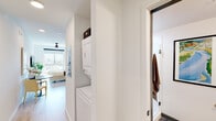 Located at 300 18th St S in Birmingham, Alabama, this modern studio offers a thoughtfully designed open-concept layout that seamlessly integrates living, sleeping, dining, and cooking into a single, well-appointed space. Light wood-look flooring runs throughout, lending warmth and continuity to the interior, while recessed lighting and a ceiling fan provide comfort and ambiance.

The kitchen is a standout feature, outfitted with dark, wood-toned cabinetry that extends to the ceiling for ample storage, stainless steel appliances — including a refrigerator, range, microwave, and dishwasher — and a striking dark tile backsplash that adds visual contrast. A compact dining area with a round marble-top table sits adjacent, making efficient use of the space.

The sleeping area is positioned near a large window that frames views of the surrounding Birmingham cityscape, filling the room with natural light. A full-height storage cabinet integrated into the kitchen zone provides additional organizational flexibility.

A dedicated hallway connects to the bathroom, which features mixed-tone luxury vinyl plank flooring, a glass-enclosed shower, and clean white fixtures. Conveniently nestled in the hallway is a stacked in-unit washer and dryer, adding a practical amenity to this efficiently designed urban residence.