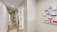 Located at 5541 Foothills Dr in Williamsburg, Michigan, this single-floor, 2-bedroom, 2-bathroom home offers a thoughtfully designed layout with modern finishes throughout. The open-concept living, dining, and kitchen area forms the heart of the home, bathed in natural light from large windows and a sliding glass door that opens to the outdoors. The kitchen is outfitted with white shaker cabinets, granite countertops, stainless steel appliances, and light hardwood-style flooring that extends throughout the main living areas. The dining area provides a bright, windowed nook ideal for everyday meals. The hallway is a standout feature, showcasing stylish barn-style sliding doors with black hardware that add a contemporary farmhouse touch. The spacious primary bedroom includes multiple windows, plush carpeting, a ceiling fan, and a generous walk-in closet with wire shelving for ample storage. The bathrooms feature white shaker vanities with granite countertops, large mirrors, and clean, neutral finishes. A dedicated laundry room with full-size washer and dryer adds everyday convenience. Throughout the home, warm neutral tones, recessed lighting, and consistent finishes create a cohesive and inviting ambiance.