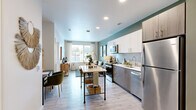 Located at 2208 Mildred St W in University Place, WA, this thoughtfully designed one-bedroom, one-bathroom residence makes excellent use of its single-floor layout. The open-concept kitchen and living area serves as the heart of the home, finished with light wood-tone flooring that enhances the bright, airy ambiance. The kitchen is outfitted with stainless steel appliances — including a refrigerator, range, microwave, and dishwasher — complemented by two-tone cabinetry featuring white upper cabinets and wood-grain lower cabinets, light quartz countertops, and a subway tile backsplash. A closet near the kitchen provides convenient additional storage. The living area benefits from large windows dressed with sheer curtains and blinds, inviting an abundance of natural light and offering outdoor views. The bedroom is a comfortable retreat with plush carpet flooring, generous windows, and access to two closets. The full bathroom features a soaking tub and shower combination with clean white tile, light wood-tone flooring, and a bright, neutral palette. Throughout the residence, sage green accent walls add a cohesive, modern character, creating a warm and inviting atmosphere ideal for everyday living.